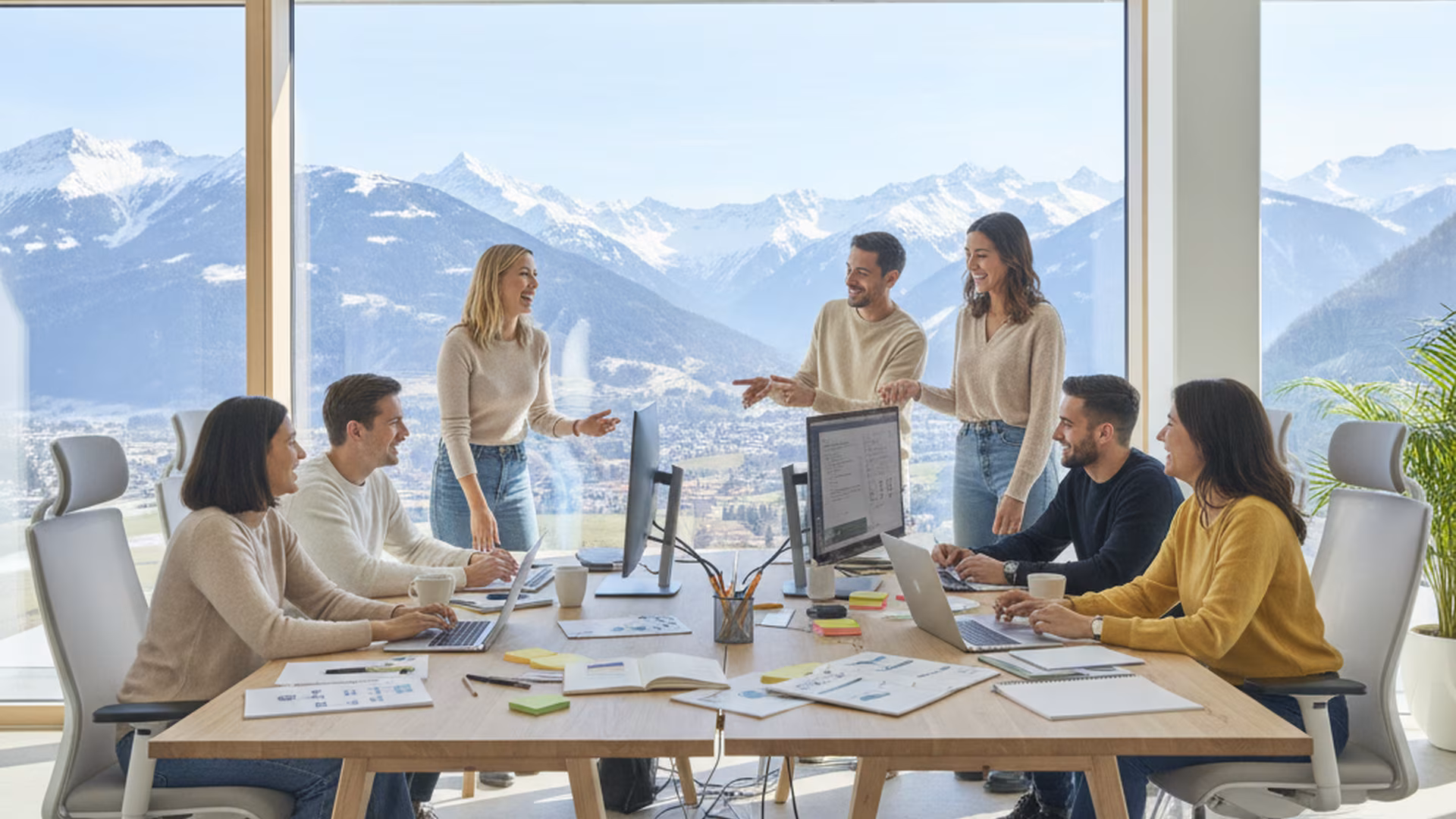 Das AlpGameCircle-Team bei der Arbeit im Büro mit Alpenblick